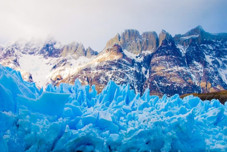 a photo of a glacier in chile and snow covered mountains