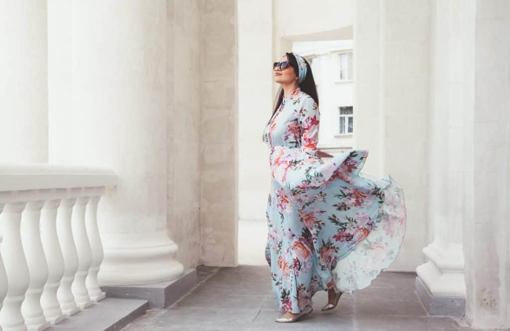 A woman in a floral print maxi dress which you should add to your Tulum packing list.