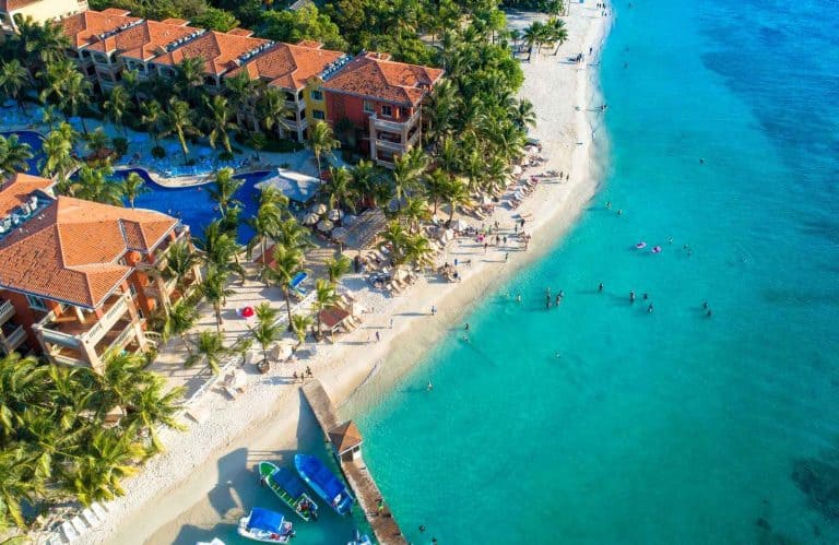 An aerial view of the sandy shores and aqua waters for a one day in Roatan trip.
