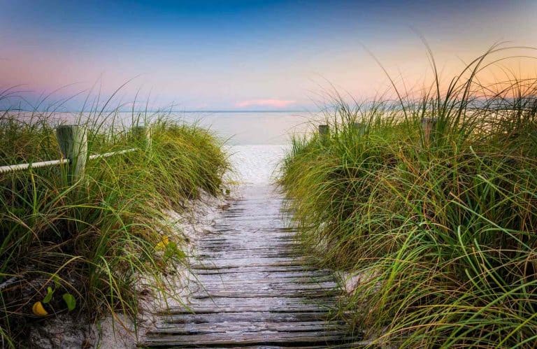 A boardwalk leading to the beach during sunset showing one of the best small beach towns in Florida.