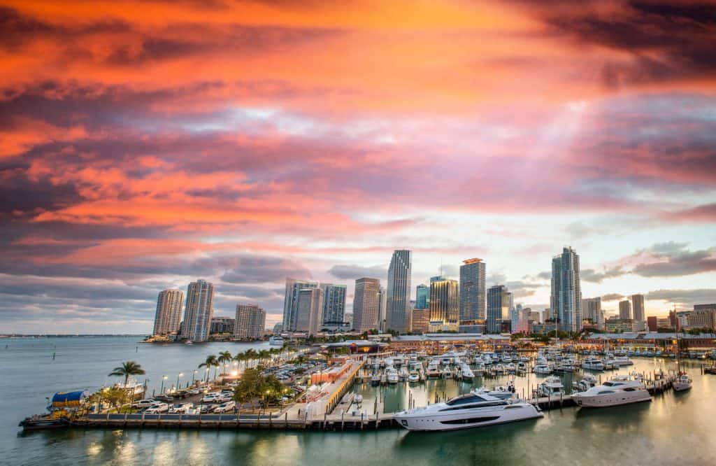 Orange skies during sunset in Miami with the skyscrapers along the ocean.