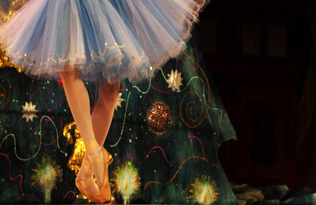 A ballet performer in a blue tutu performing The Nutcracker.