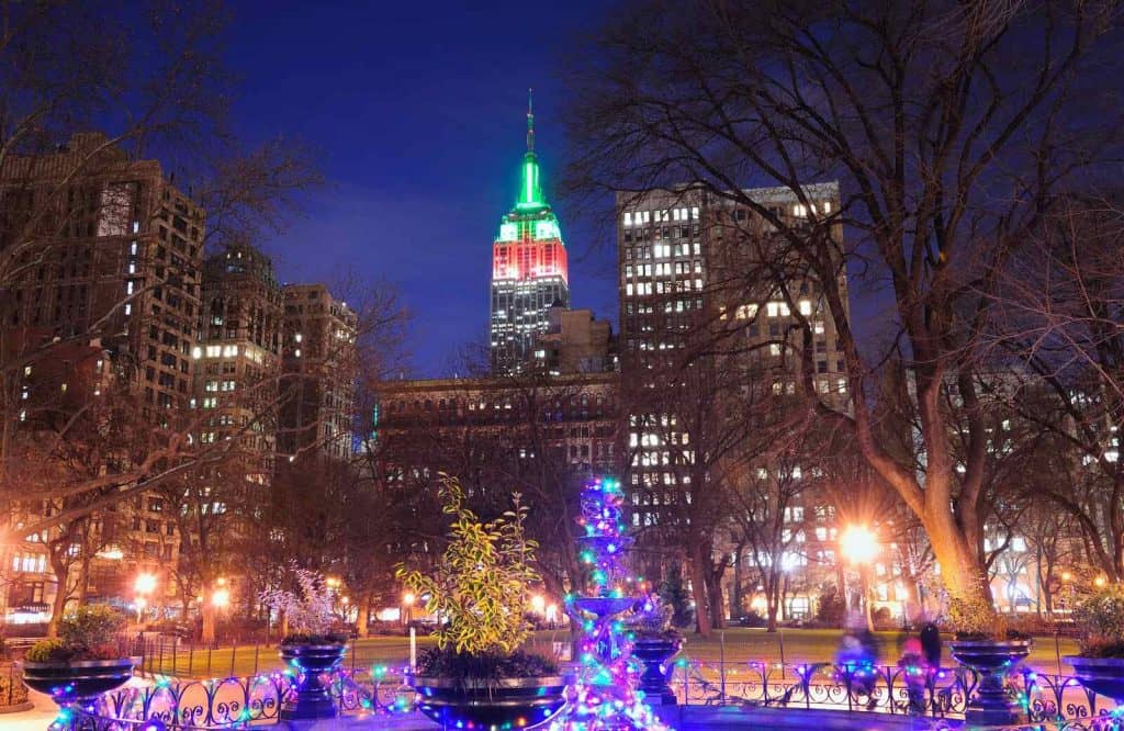 Empire State Building with green and red lights when visiting New York for Christmas.