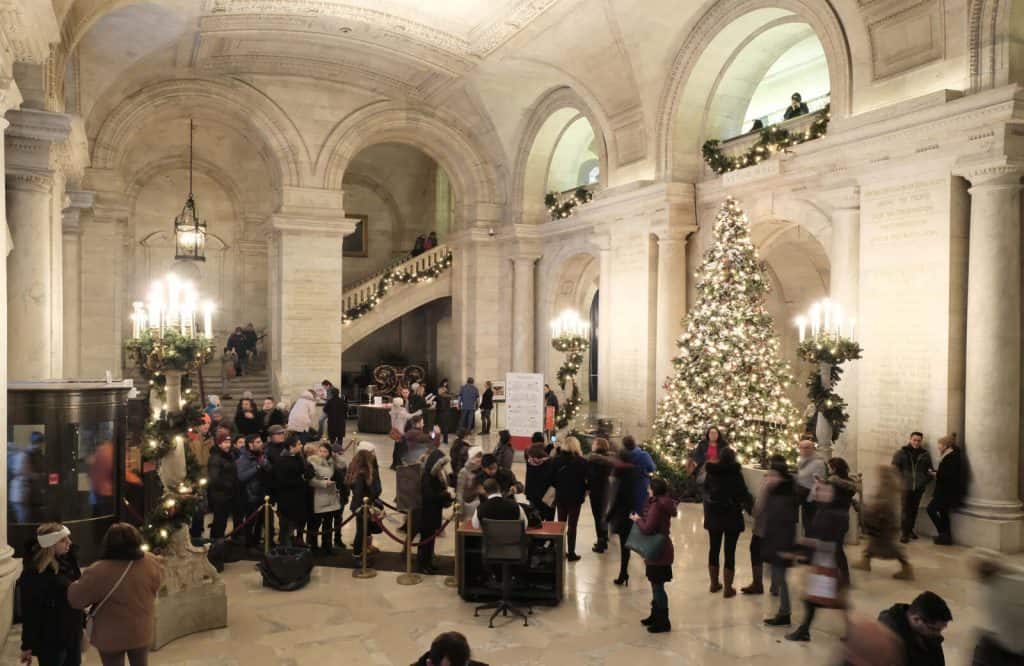 A giant lit up Christmas tree in Astor Hall in New York Public Library.