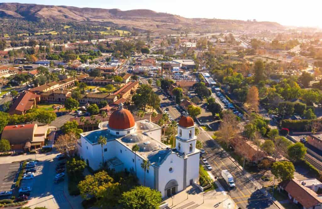 Aerial view of San Juan Capistrano with buildings surrounded by the mountains.