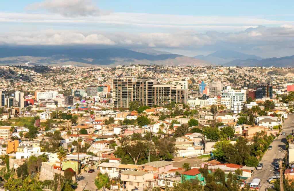 Aerial view of Tijuana, Mexico with lots of buildings and the mountains in the background.