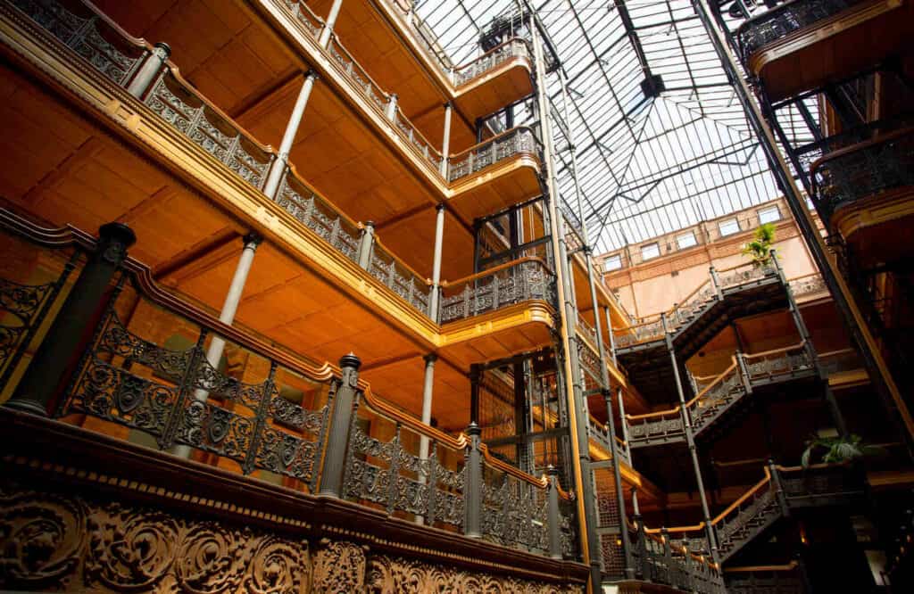 The classical interior of the Bradbury Building in Downtown LA with light coming through the roof.