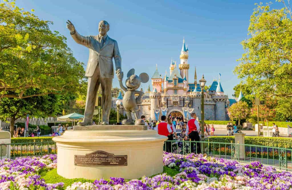 Disneyland Park with a statue of Walt Disney and the Sleeping Beauty Castle in the background, which is one of the coolest Los Angeles day trips.