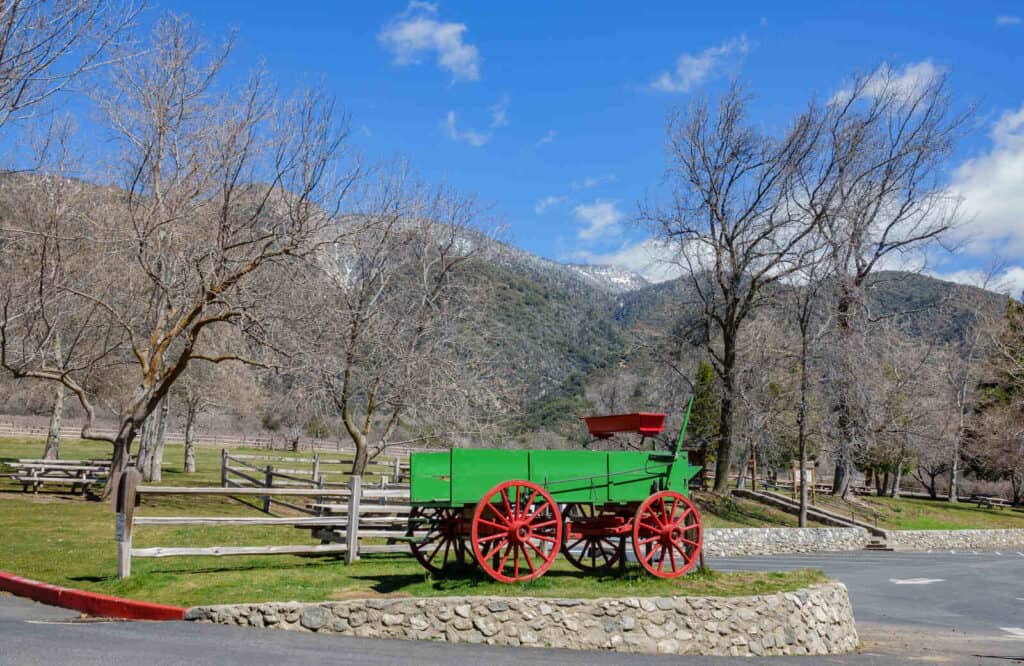 Green and red tractor at Oak Glen Preserve in Ojai with mountains in the background.