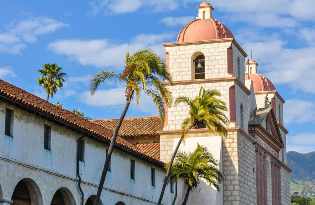 Old Mission Santa Barbara with its white building with orange roof constructed in a Spanish Colonial style.