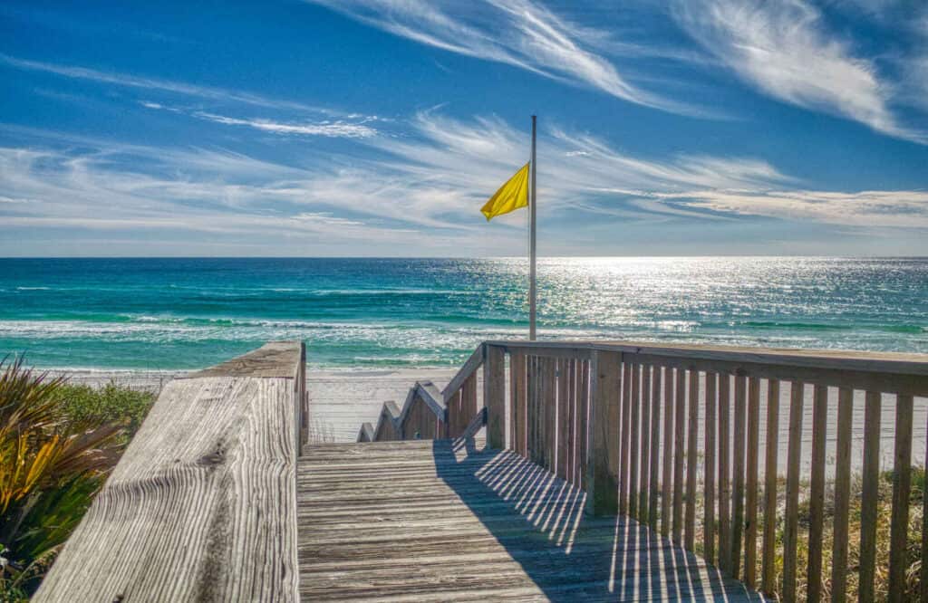 A boardwalk leading down to Blue Mountain Beach with white powdery sand and turquoise waters.