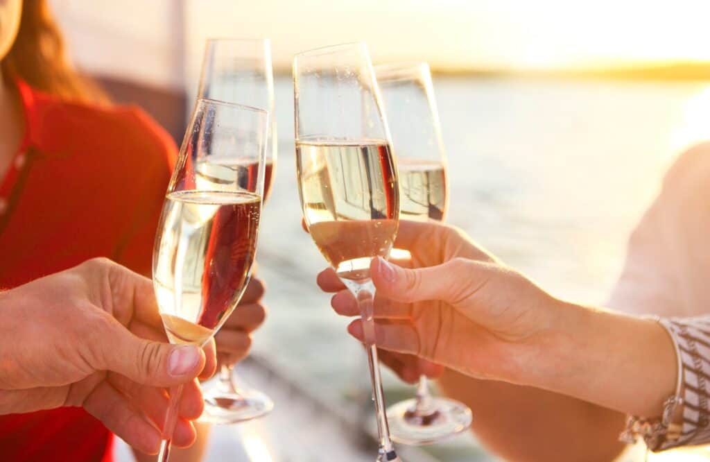 A group of friends making a toast on a boat during sunset.